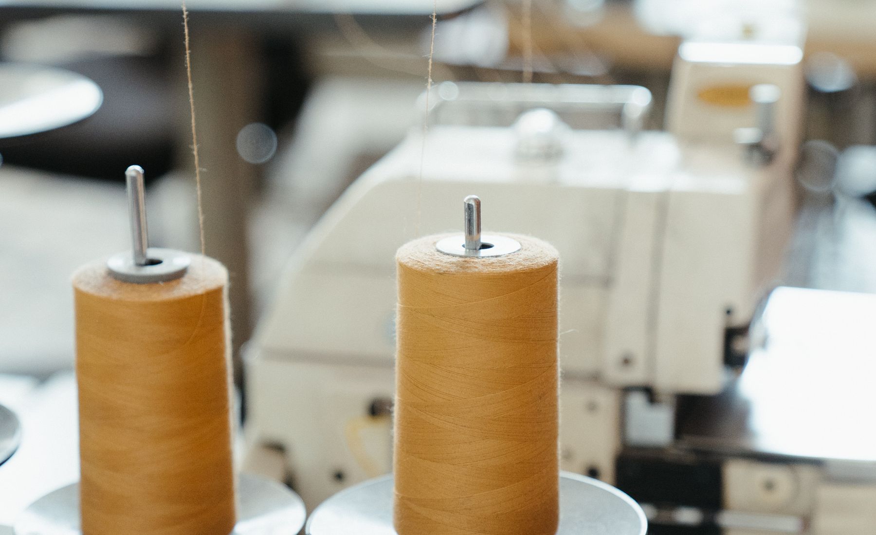 Thread spools beside an industrial sewing machine